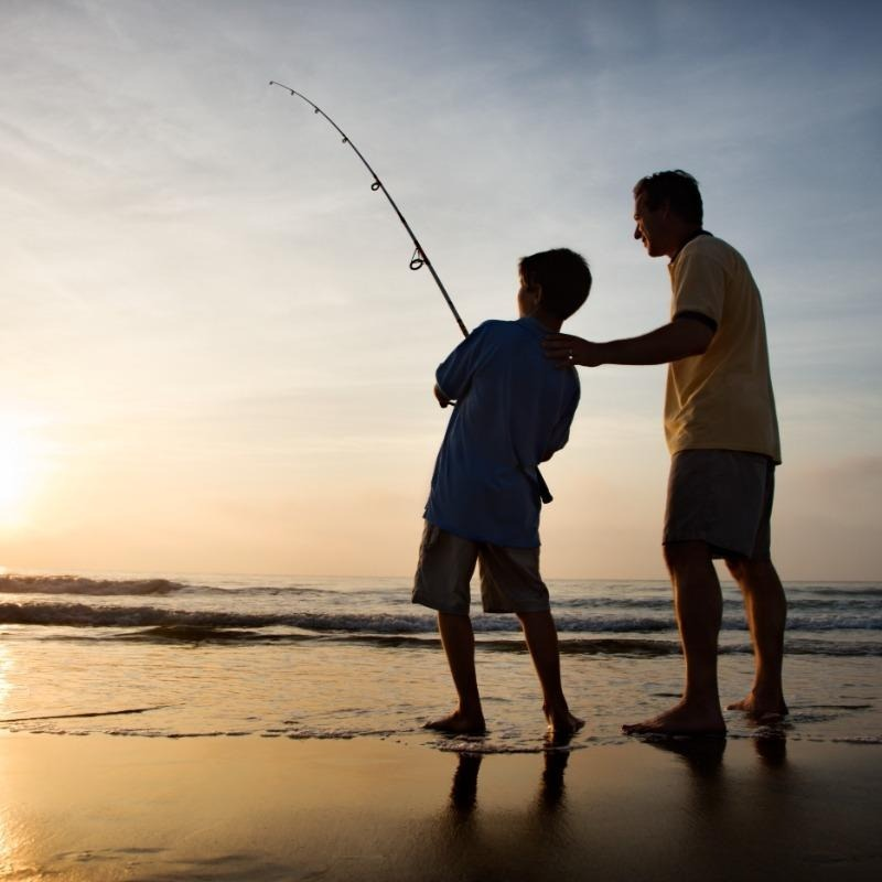 Father and son fishing on the beach
